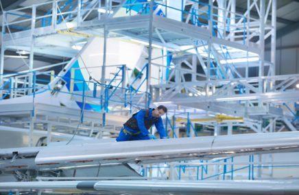 EFKNY8 Engineer working on aircraft wing in aircraft maintenance factory